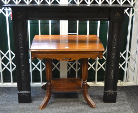 An early-20th century black painted fire surround; a Victorian Gothic Revival stained pine and mahogany side table, shaped to