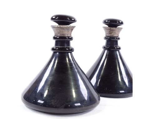 A pair of 19th century dark turquoise glass ship's decanters, with unmarked silver collars, height 23c, diameter 20cmNo chips