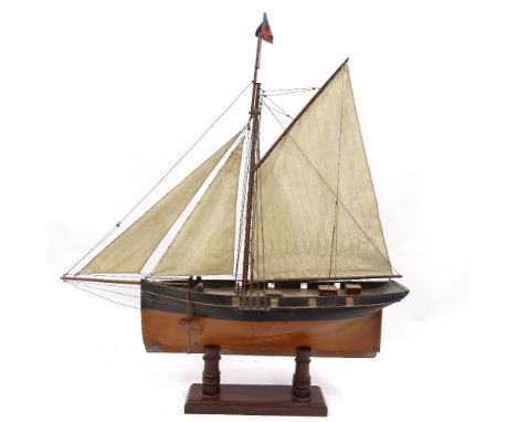 A Victorian painted wood hulled model pond yacht, with sales and rigging, hull length 57cm, on wooden stand, overall height 8