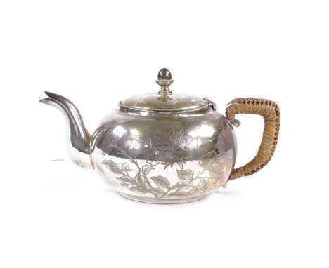 An American Arts and Crafts sterling silver squat teapot, engraved floral decoration with acorn knop and caned handle, height