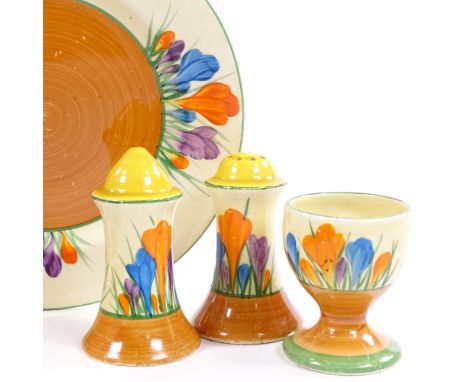 A Clarice Cliff for Newport Pottery Crocus pattern sandwich plate and pair of cruet pepperettes, and a Wilkinson egg cup, pla