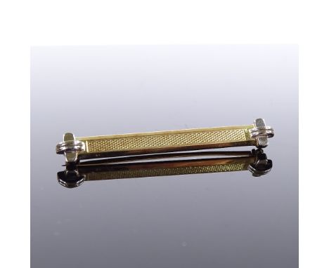 An Art Deco 15ct gold bar brooch, 18ct white gold tips with engine turned decoration, maker's marks M and M, brooch length 46