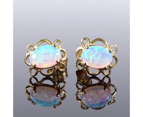 A pair of unmarked gold cabochon opal earrings, pierced flower style settings, stud fittings, earring height 9.7mm, 0.9gBoth 