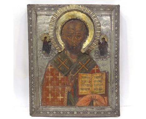 A Russian silver-fronted icon, 18th or 19th century, painted portrait of a saint with Cyrillic inscription and gilded silver 