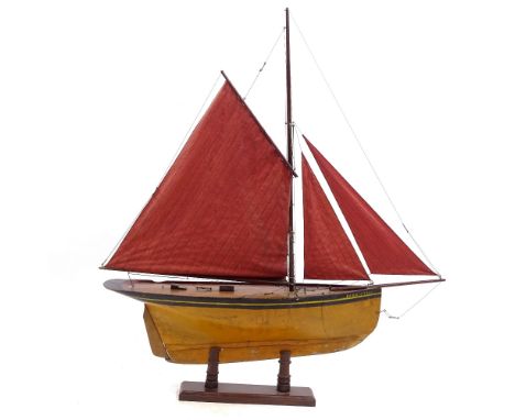 A Victorian wooden hulled model pond yacht, with sails and rigging, hull length 72cm, on wood stand, overall height 1m 