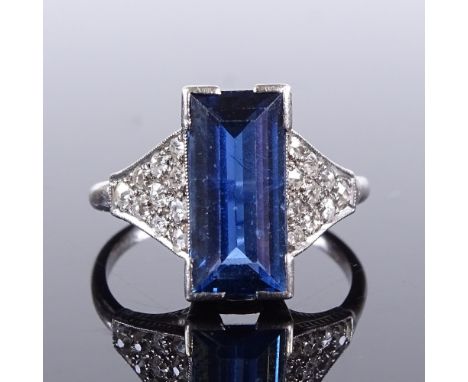 An Art Deco platinum sapphire and diamond cluster panel ring, rectangular-cut sapphire approx 2.6ct, setting height 12.3mm, s