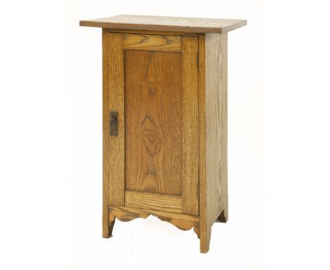 An oak pot cupboard,designed by Ambrose Heal for Heal and Son, with a plain panelled cupboard enclosing a shelf, with an embo