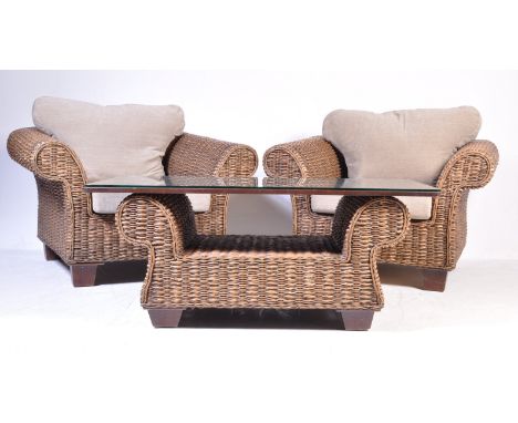 A pair of vintage 20th Century wicker / easy / lounge / conservatory armchairs having curved arms with cushioned seats and ra