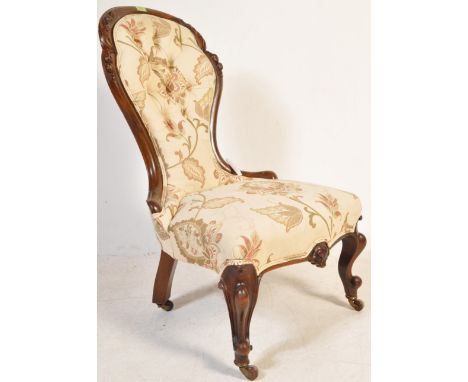 A 19th century Victorian spoon back nursing chair having a chesterfield style button back rest with a mahogany show wood fram