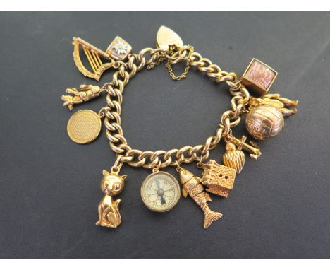 A curb-link bracelet suspending an assortment of twelve charms - To include a harp, an articulated fish and a compass - Brace
