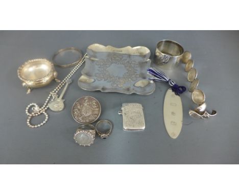 An assortment of silver items including two rings, bracelet, napkin ring, salt, vesta, necklace, small engraved tray and a Lo