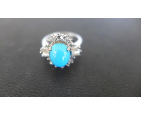 A ladies platinum dress ring, the central sky blue stone surrounded by fourteen small diamonds and six baguette cut diamonds 