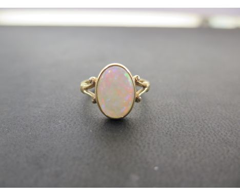 An 18ct gold opal single-stone ring - To the bifurcated shoulders and plain band - Hallmarked Sheffield - Ring size Q - Weigh