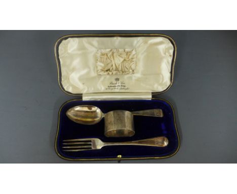 A silver hallmarked cased Christening set consisting of spoon, fork and napkin ring approx weight 2 troy oz bearing engraved 