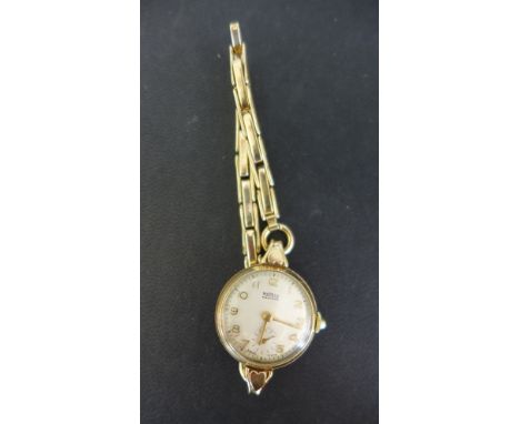 A 9ct yellow gold cased ladies Rotary wristwatch with rolled gold bracelet, the Champagne coloured dial with Arabic numerals,