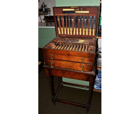 A 1930's oak canteen of plated flatware on oak barley twist stand 