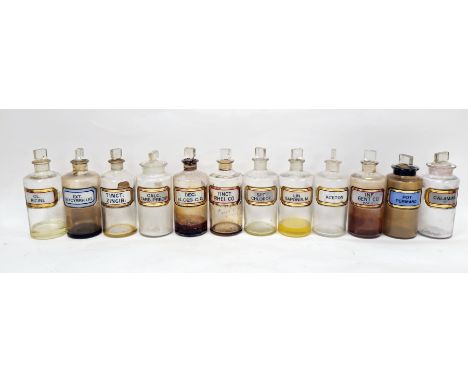Twelve early 20th century 'label under glass' apothecary bottles, each of cylindrical form with assorted faceted rectangular 