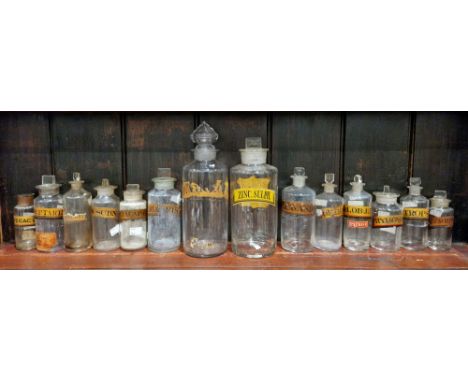 Two large and twelve various small late 19th/early 20th century labelled glass apothecary bottles and assorted stoppers, each