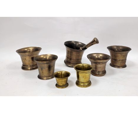 19th century bell metal pestle and mortar having a ringed body and rounded base, mortar 13cm high together with a further six