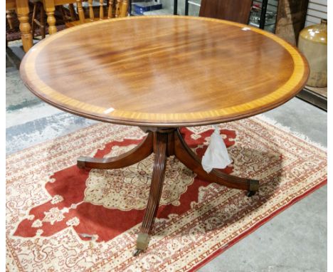 Arthur Brett of Norwich mahogany and satinwood crossbanded oval extending dining room table, the circular top extending with 