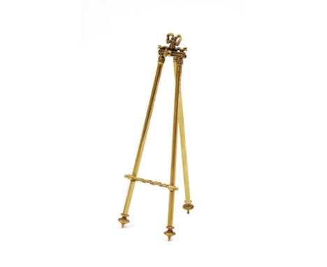 Late Victorian/Edwardian brass miniature easel-back stand, perhaps for a watch or miniature, the top cast with ribbons, with 