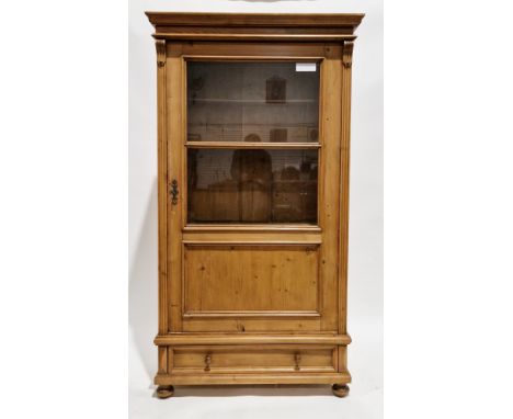 19th century continental pine part glazed cupboard, the moulded pediment over a single door with two glass panels and a solid