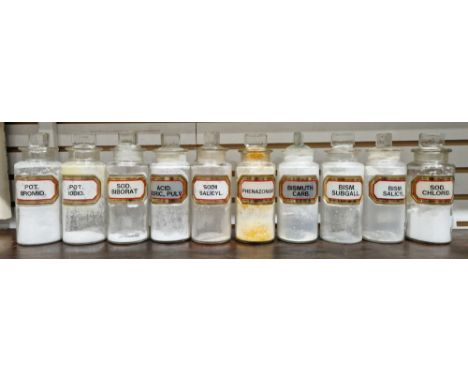 Ten small early 20th century 'label under glass' apothecary bottles and stoppers, each of cylindrical form with assorted face