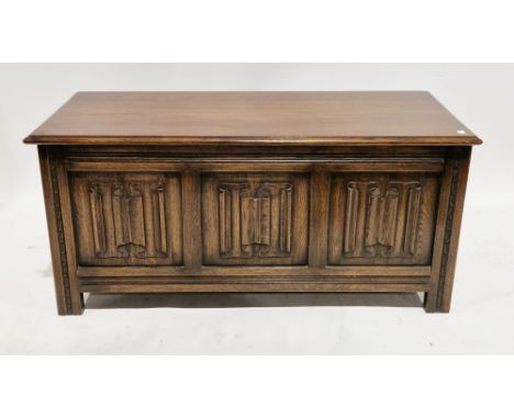 Oak coffer in the 17th century manner, the hinged top with thumbmould edge, three front panels with linenfold carving, on sti