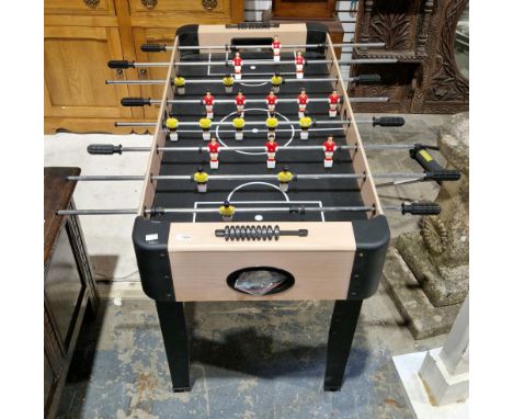 Pot Black children's 4ft football table, the plastic players in red and yellow kit, on telescopic rods with grips, held on a 