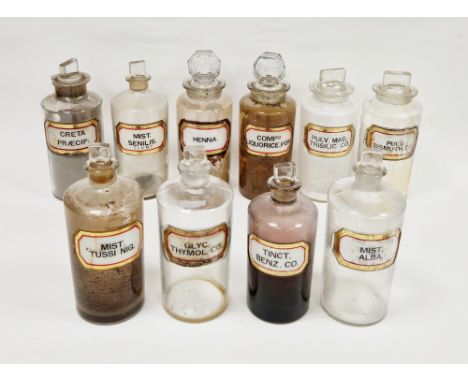 Ten large early 20th century 'label under glass' apothecary bottles and stoppers, each of cylindrical form with faceted recta