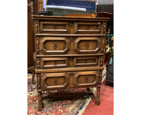 A Jacobian style oak chest of four drawers with oak lined geometric moulded drawers and drop handles on bracket feet, H115cm,