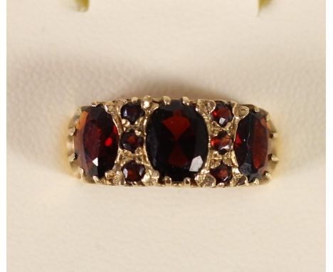 A 9ct gold and garnet three stone ring, 4.2gm, N. 