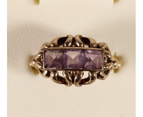 An unmarked gold and amethyst three stone ring, 2.8 gm, N. 