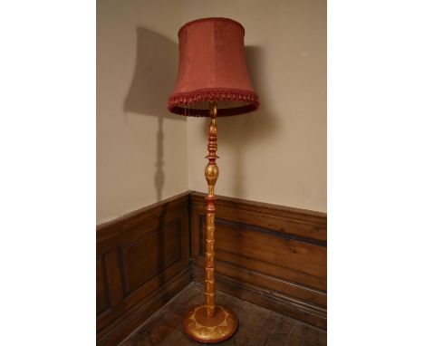 An Eastern lacquered and gilded standard lamp on circular base with stylised foliate motifs. H.184cm (inc. shade) Dia.40cm (b
