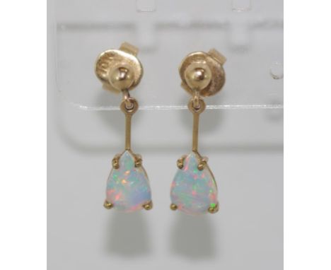 Gold and solid opal drop earrings marked 10K, well matched stones with flashes of red in both, weight: approx 1.9 grams