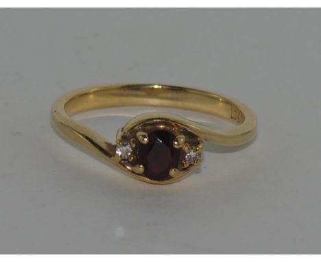 9ct yellow gold, garnet & diamond set ring the central garnet, with a small diamond to each side. Total weight 3gm, size: N/7