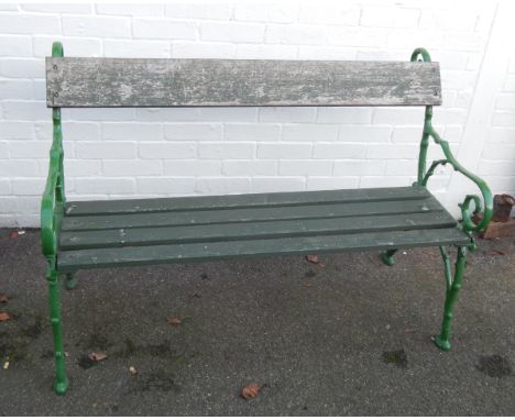 A cast iron and wooden slatted garden bench, with scrolling branch ends, painted green, 128cm long.