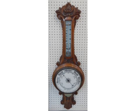 A Victorian oak cased barometer with thermometer, foliate carved, presentation plaque, 86cm long.