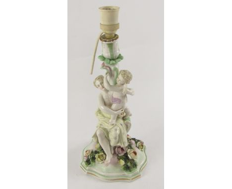 A Sitzendorf porcelain 20thC table lamp, modelled with Venus and a putto, raised on a serpentine base encrusted with flowers,