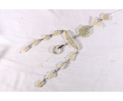 Carved and pierced jade hanging suspended from a pierced circular jade carving, comprising a shaped oval panel 9cm x 3cm, car
