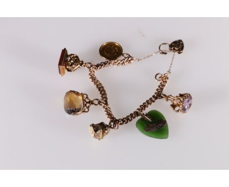 9ct gold curb link charm bracelet set with 1/2 tola gold coin, 9ct gold nugget charm, three fobs and a jade heart pendant, 59
