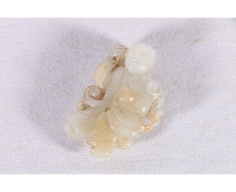 Chinese carved jade figure of a man as a pendant or decorative bead, holding streaming ribbons in his left hand, hole bored f