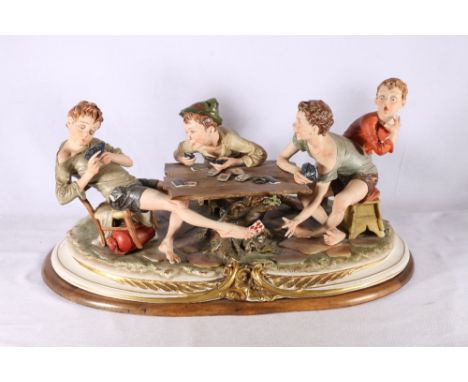 Capodimonte porcelain figure group of four young boys playing cards titled "The Card Cheat", 50cm long 
