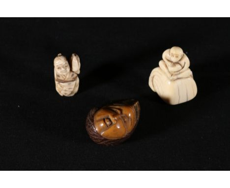 19th Century ivory netsuke of a monkey seated on a large bag, 4.5 cm, a netsuke carved from a seed, as a shawled face and ano