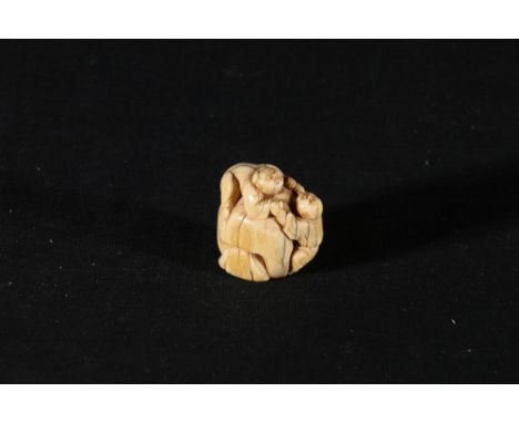 19th Century ivory netsuke of two children clambering over a large bag, 4 cm. Condition Report:Some discolouration, old crack