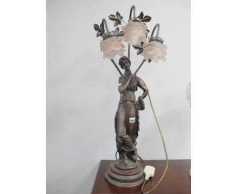 A Resin Table Lamp, in the form of a Lady supporting three pink glass shades, 81cm high.