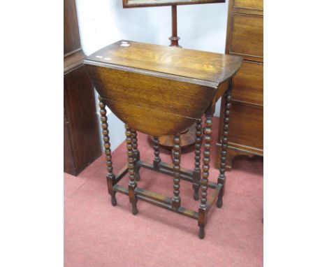 A 1920's oak Gate leg Table, with oval top and bobbin supports, 54.5cm wide.