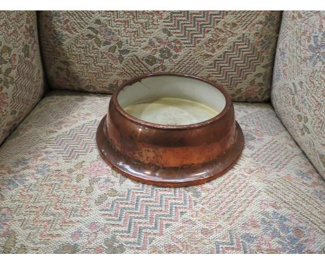 A copper cased dogs bowl on steel base with enamel interior