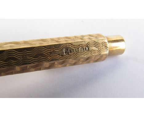A 9ct gold telescopic toothpick in an engine turned casing 