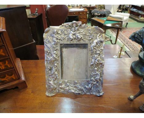 A silvered bronze easel frame, decorated with putti